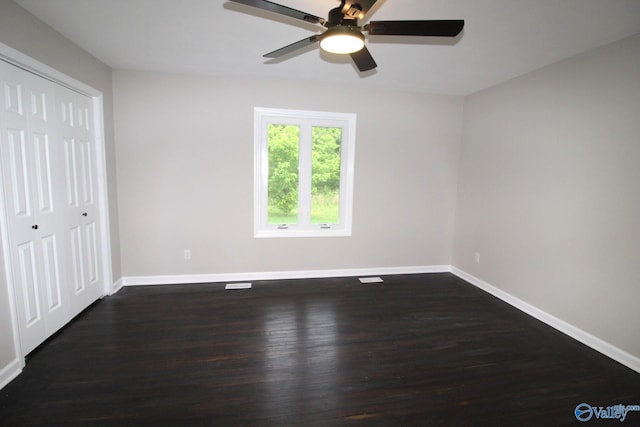 unfurnished bedroom featuring dark hardwood / wood-style flooring, a closet, and ceiling fan