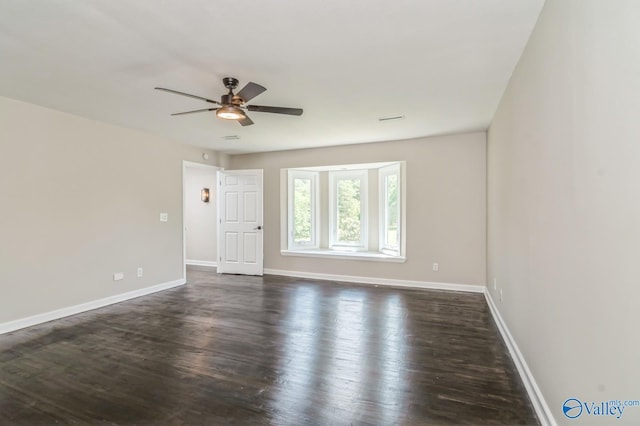 unfurnished room featuring dark wood-type flooring and ceiling fan