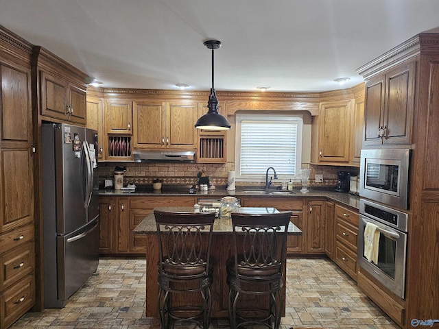 809 Kyle Rd NE, Hartselle, AL 35640 - kitchen featuring stainless steel appliances, a sink, under cabinet range hood, backsplash, and hanging light fixtures