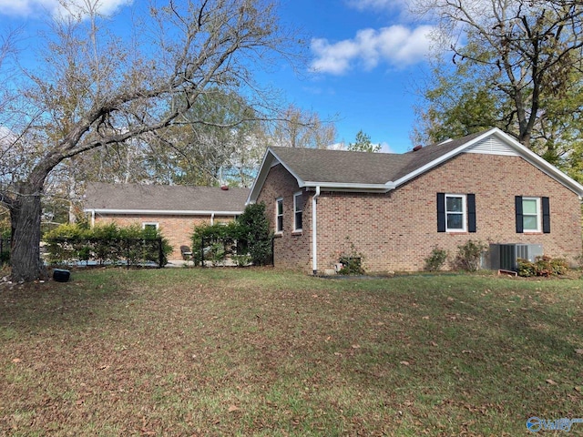 view of side of property with a lawn and central air condition unit