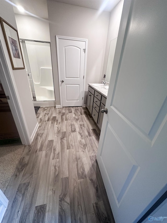 117 Edensmith Dr, New Market, AL 35761 - bathroom featuring a stall shower, vanity, wood finished floors, and baseboards