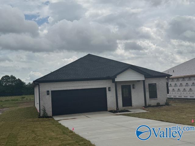 17194 Red Hill Rd, Athens, AL 35611 - ranch-style home with an attached garage, concrete driveway, a front yard, and brick siding