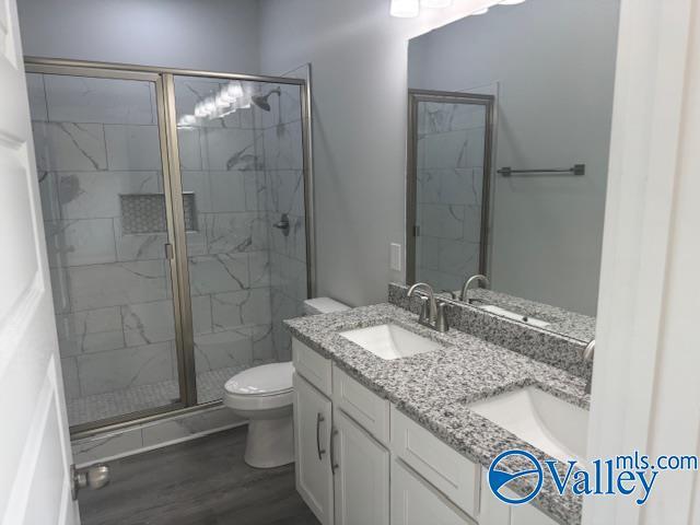17194 Red Hill Rd, Athens, AL 35611 - full bath featuring double vanity, a shower stall, and wood finished floors