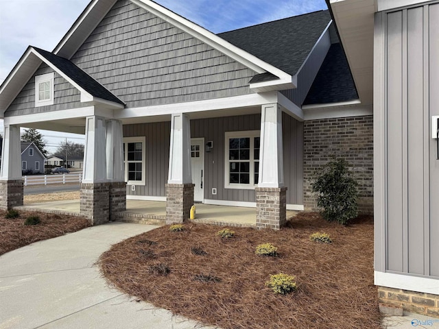 craftsman-style house with board and batten siding, brick siding, and a porch