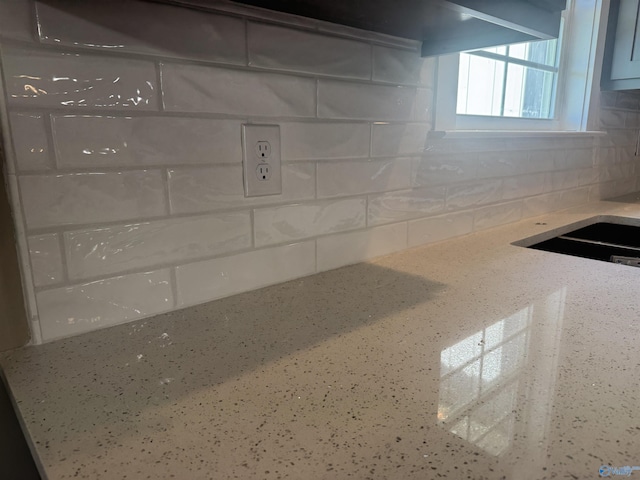 details featuring tasteful backsplash and light stone countertops