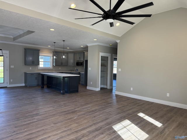 kitchen featuring a textured ceiling, dark wood-style flooring, open floor plan, light countertops, and crown molding