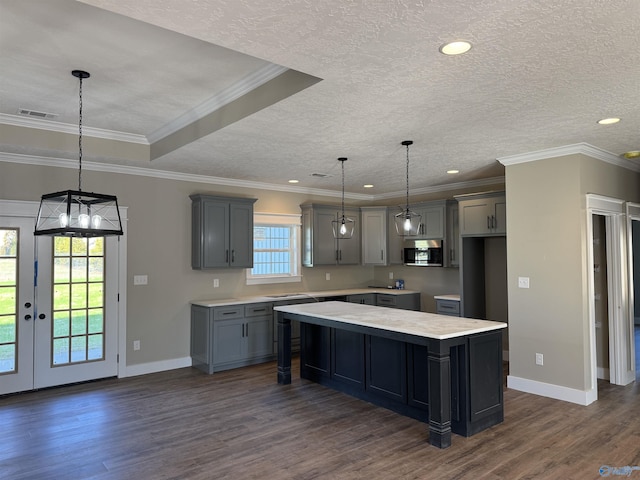 kitchen with stainless steel microwave, dark wood finished floors, and gray cabinetry