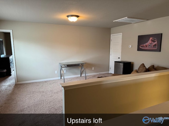 unfurnished living room with baseboards and carpet