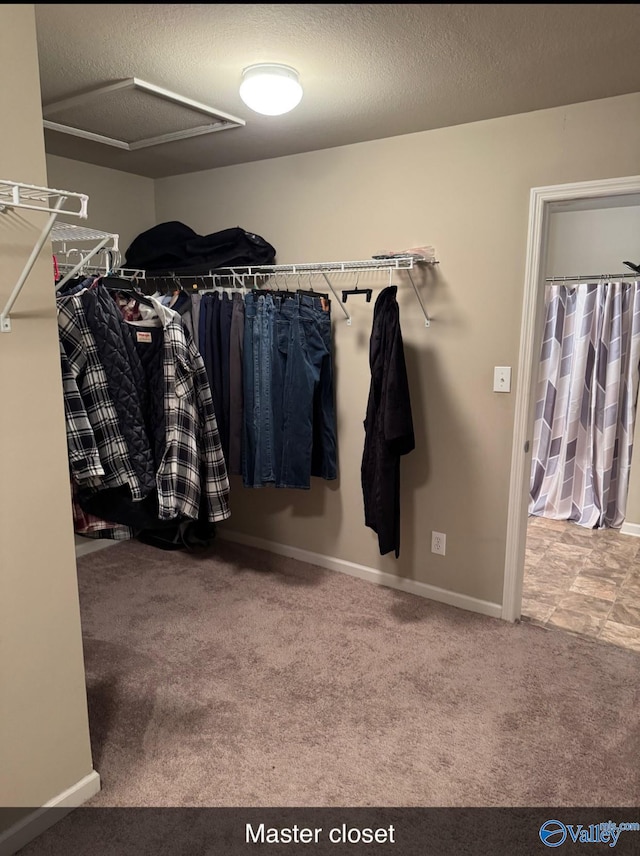 walk in closet with carpet flooring and attic access