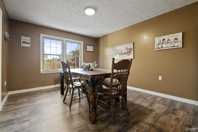 dining space featuring a textured ceiling and dark hardwood / wood-style floors