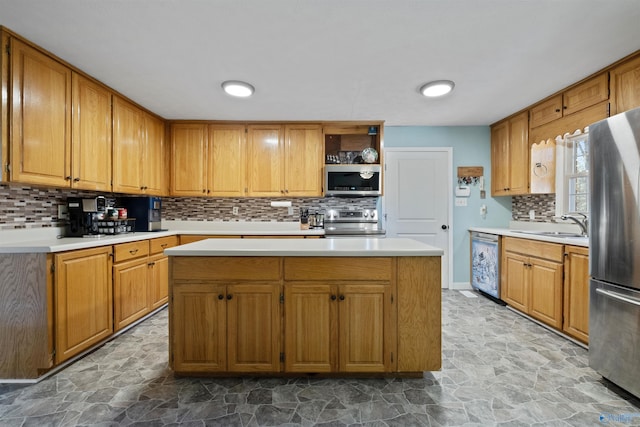 kitchen with decorative backsplash, appliances with stainless steel finishes, a kitchen island, and sink