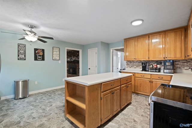 kitchen with a brick fireplace, backsplash, a kitchen island, and ceiling fan