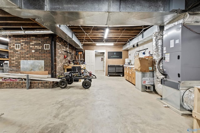 basement featuring heating unit and brick wall