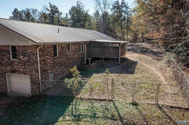 exterior space featuring central AC, a garage, and a sunroom