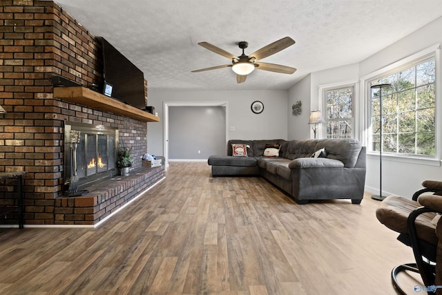 living room featuring a fireplace, light hardwood / wood-style flooring, and a textured ceiling