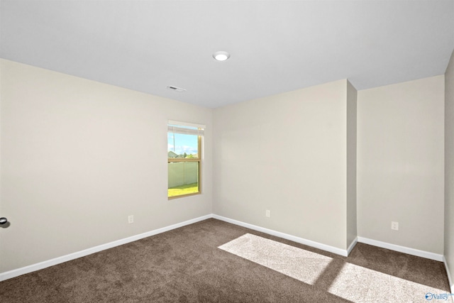 spare room with dark carpet