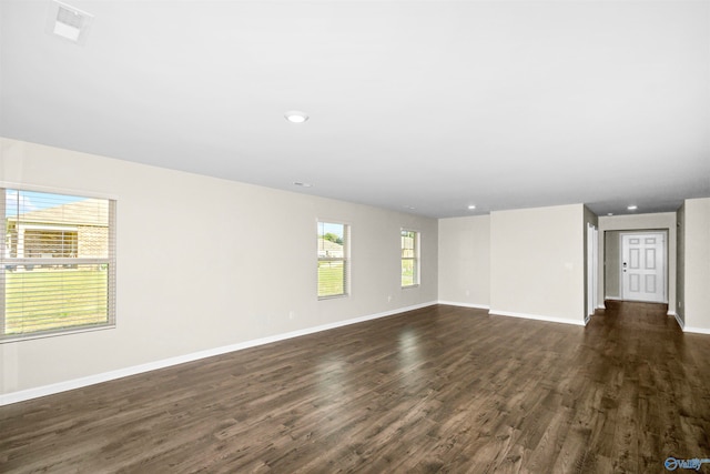 empty room with dark wood-type flooring and plenty of natural light