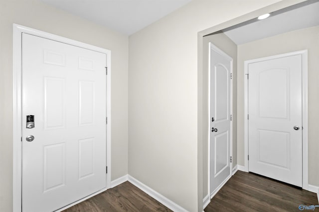 foyer entrance with dark wood finished floors and baseboards