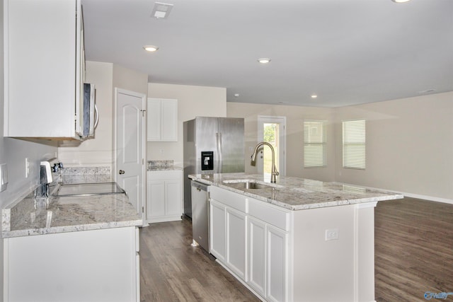 kitchen with appliances with stainless steel finishes, light stone counters, sink, dark wood-type flooring, and a kitchen island with sink