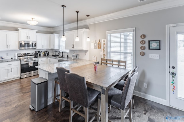 dining room featuring sink, ornamental molding, and a healthy amount of sunlight