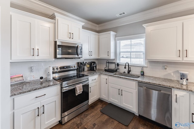 kitchen with stainless steel appliances, white cabinetry, and sink