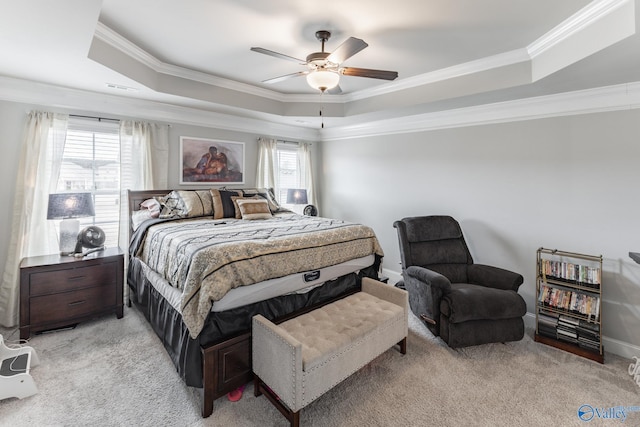 bedroom featuring a raised ceiling, ornamental molding, light carpet, and ceiling fan