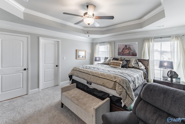 carpeted bedroom featuring multiple windows, a raised ceiling, ornamental molding, and ceiling fan