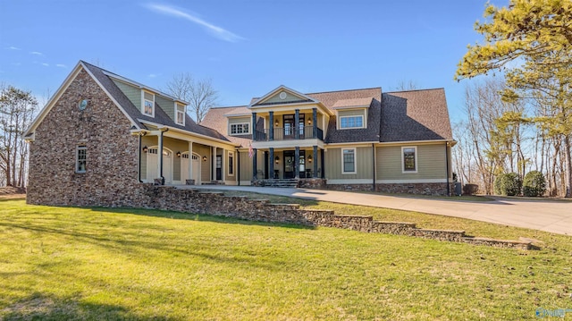 view of front of house featuring a front lawn and a balcony