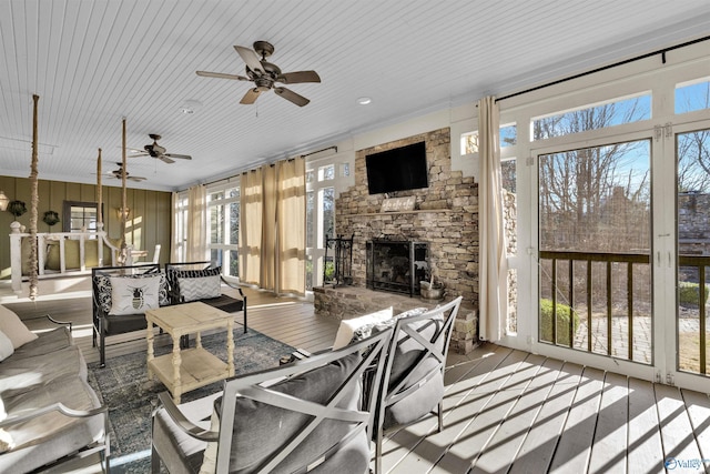 sunroom featuring a stone fireplace