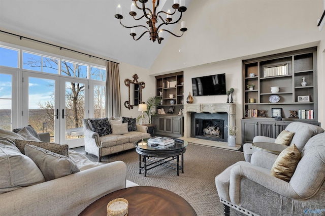 living room with french doors, built in shelves, high vaulted ceiling, and a premium fireplace