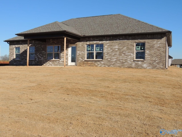 rear view of house featuring a lawn