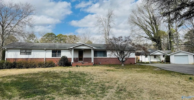 ranch-style house featuring an outbuilding, driveway, brick siding, and a front yard