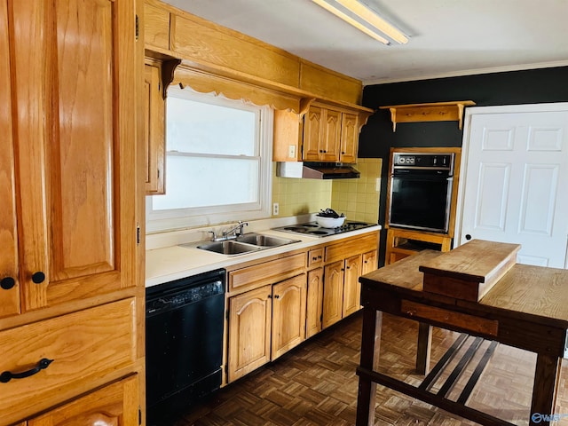 kitchen featuring under cabinet range hood, a sink, light countertops, black appliances, and tasteful backsplash