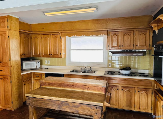 kitchen featuring electric cooktop, white microwave, a sink, black oven, and under cabinet range hood