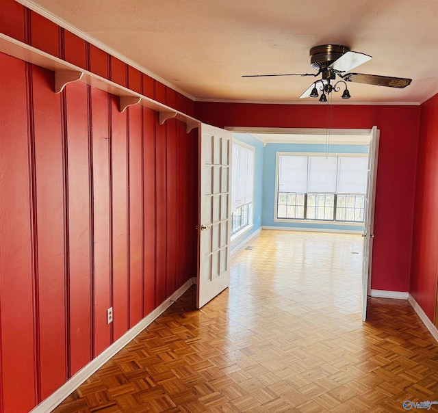 spare room with ornamental molding, visible vents, baseboards, and a ceiling fan