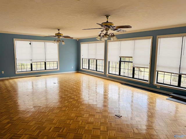 spare room with a healthy amount of sunlight, a textured ceiling, and baseboards