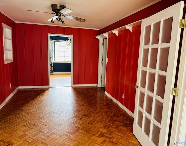 unfurnished room with ceiling fan, baseboards, and crown molding