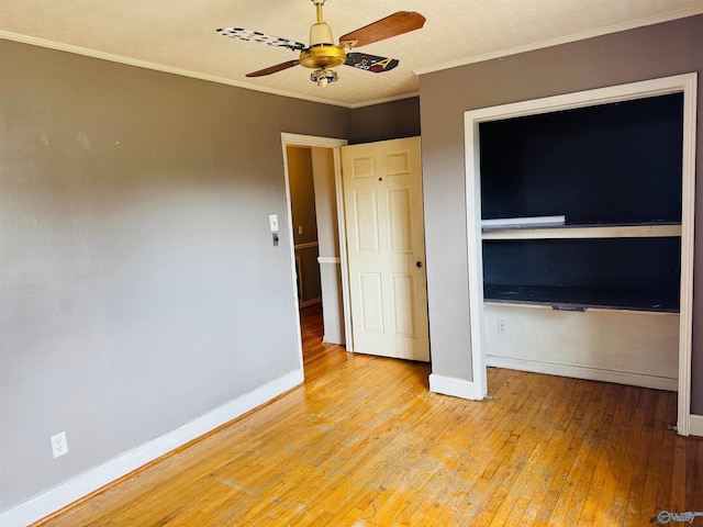 unfurnished bedroom featuring light wood-type flooring, baseboards, ornamental molding, and a ceiling fan