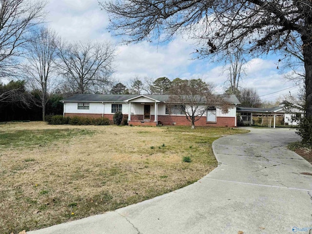 ranch-style house with brick siding, concrete driveway, covered porch, a carport, and a front lawn