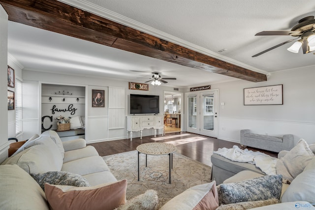 living room featuring beam ceiling, crown molding, built in features, and hardwood / wood-style flooring