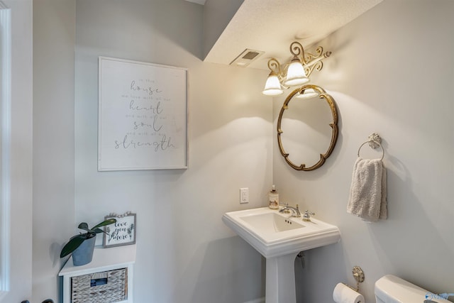 bathroom featuring sink, a textured ceiling, and toilet