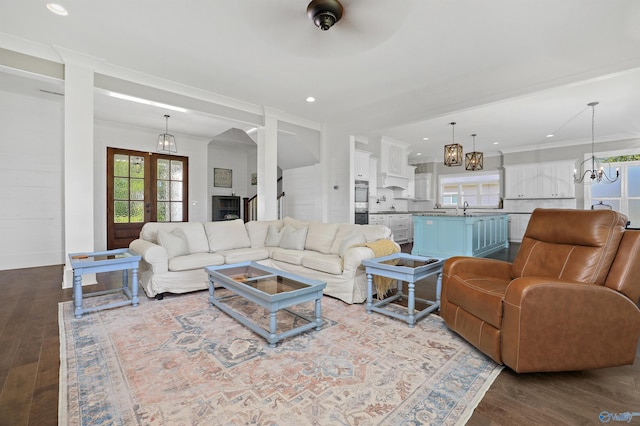 living area featuring crown molding, wood finished floors, and french doors