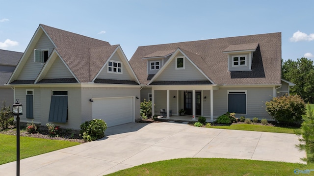 view of front facade featuring a garage, a shingled roof, concrete driveway, a porch, and a front yard