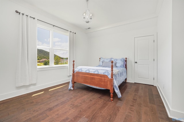 bedroom with a notable chandelier, visible vents, baseboards, and dark wood-style flooring