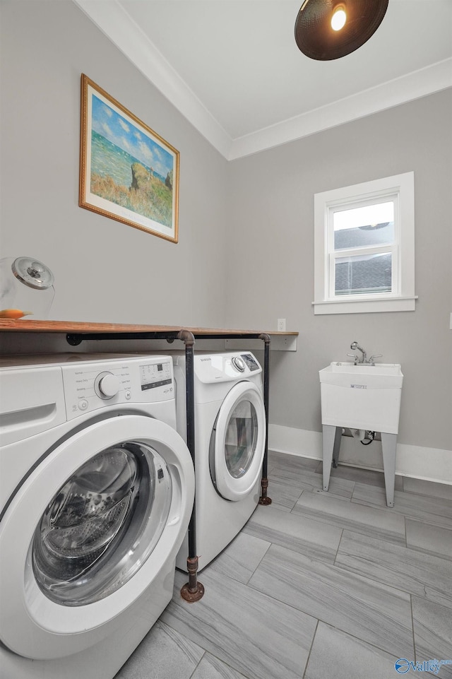 laundry room with baseboards, laundry area, washing machine and clothes dryer, and crown molding