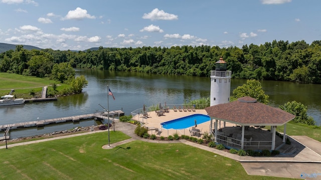 view of pool with a patio, a water view, a gazebo, a fenced in pool, and a wooded view