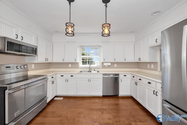 kitchen featuring white cabinetry, sink, hanging light fixtures, and appliances with stainless steel finishes