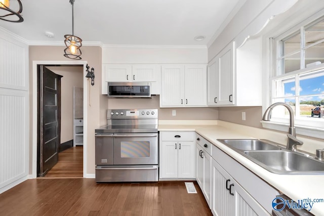 kitchen featuring sink, hanging light fixtures, stainless steel appliances, dark hardwood / wood-style floors, and white cabinets