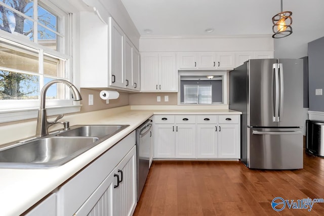 kitchen with appliances with stainless steel finishes, dark hardwood / wood-style floors, white cabinetry, and sink