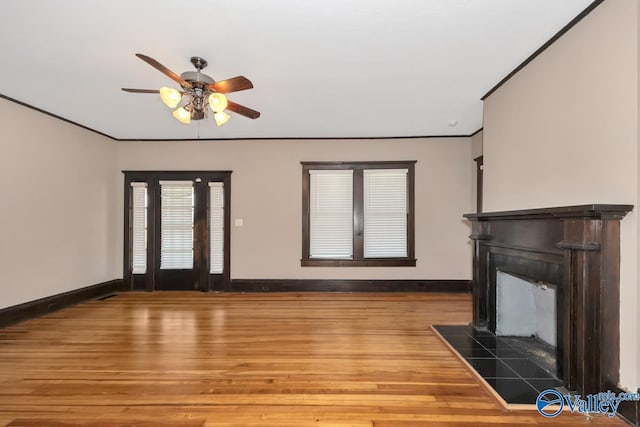 unfurnished living room with ceiling fan, crown molding, and hardwood / wood-style flooring